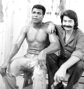 Celebrity sports artist Leroy Neiman is pictured with Muhammad Ali at his training camp cabin. Neiman passed away on June 20.